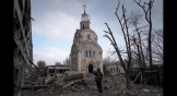 Un soldat ukrainien photographie une église endommagée après un bombardement dans un quartier résidentiel de Marioupol, en Ukraine, le 10 mars 2022.