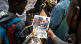 Un jeune garçon regarde une affiche présentant le lieutenant-colonel Paul-Henri Sandaogo Damiba, nouvel homme fort et chef de la junte au Burkina Faso, devant la grande mosquée de Ouagadougou après la prière du vendredi, le 28 janvier 2022.