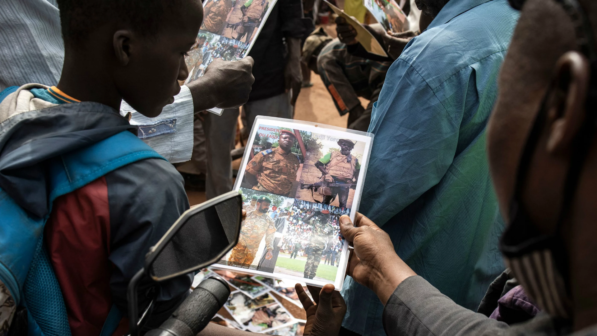 Un jeune garçon regarde une affiche présentant le lieutenant-colonel Paul-Henri Sandaogo Damiba, nouvel homme fort et chef de la junte au Burkina Faso, devant la grande mosquée de Ouagadougou après la prière du vendredi, le 28 janvier 2022.