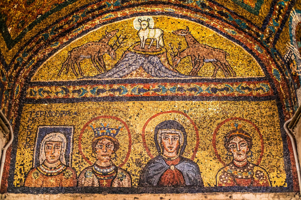 Une mosaïque de la chapelle de l’évêque Zeno à Vérone représente l’Agneau de Dieu et, en dessous, quatre femmes. Il s’agit, de droite à gauche, de Sainte Praxède, du deuxième siècle, de Marie, de la sœur de Praxède, Pudentienne, et d’une personne encore vivante à l’époque entourée d’une auréole carrée. Elle s’appelle Théodora et pourrait être la mère du pape Pascal Ier. Au-dessus de sa tête se trouve le mot grec episkopa, la forme féminine d’évêque. Certains ont affirmé que ce titre n’était qu’honorifique. La terminaison féminine de son nom a également été dissimulée.