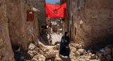 Une femme passe devant les décombres d’un bâtiment endommagé lors du tremblement de terre au Maroc.