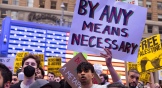 Un manifestant brandit une pancarte lors du rassemblement All Out for Palestine à Times Square, New York.