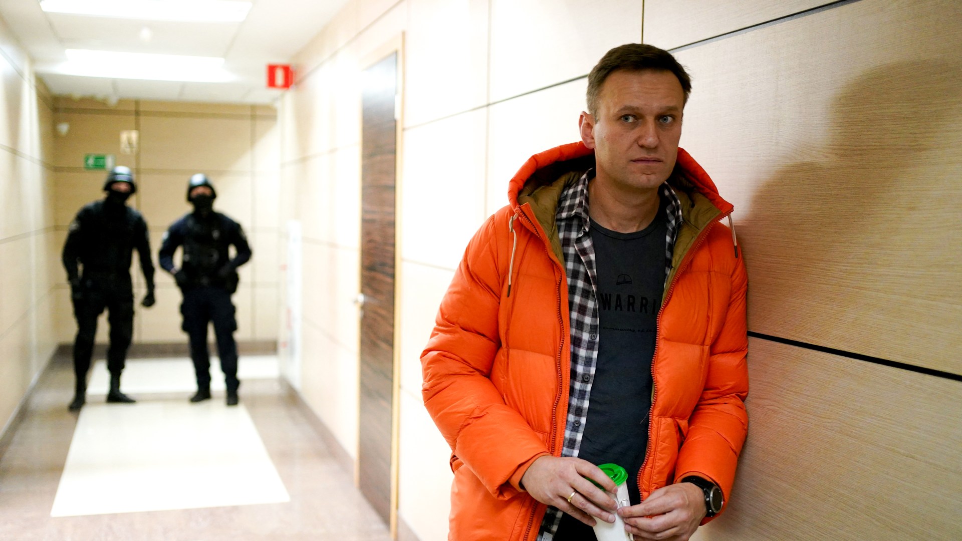 Alexei Navalny se tient à proximité d’agents des forces de l’ordre dans un couloir d’un centre d’affaires qui abrite les bureaux de sa Fondation anticorruption, à Moscou.