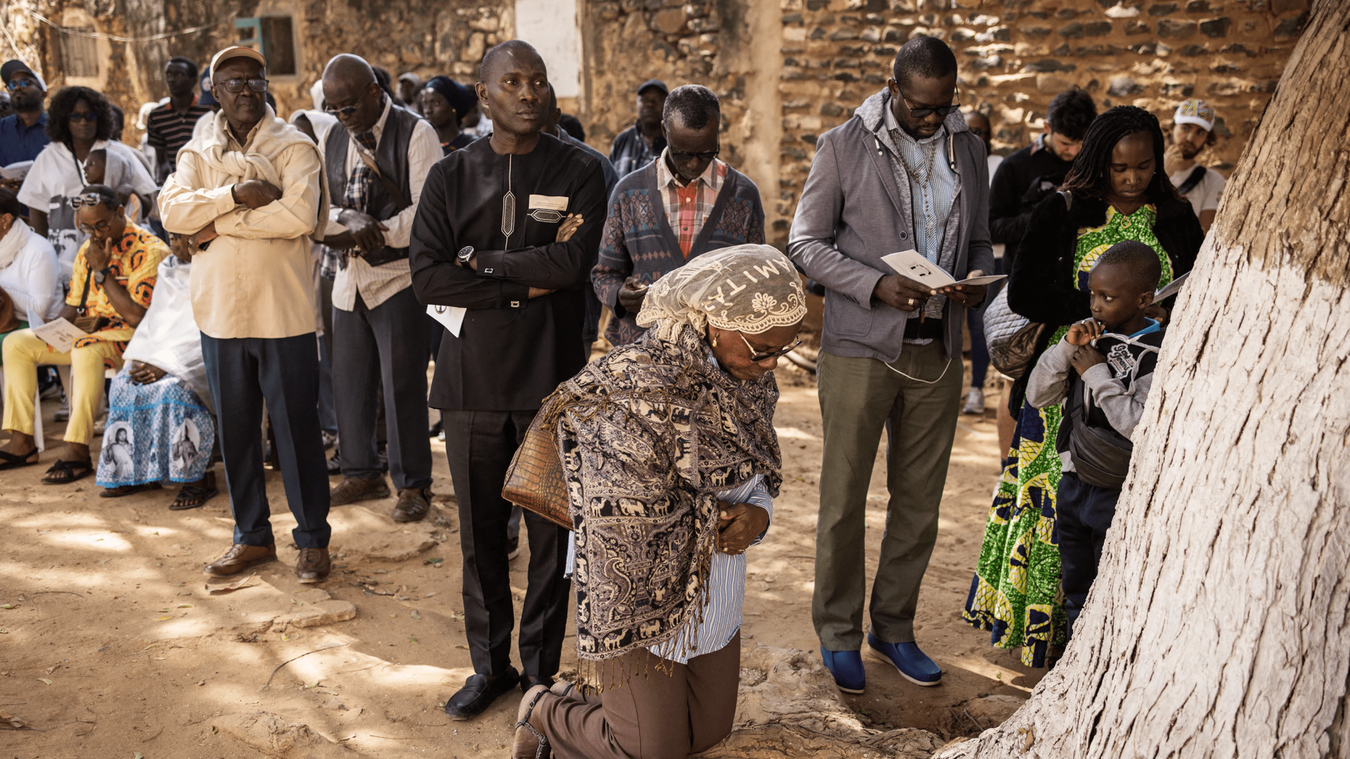 Un fidèle catholique s’agenouille pour prier à l’extérieur d’une église au Sénégal.