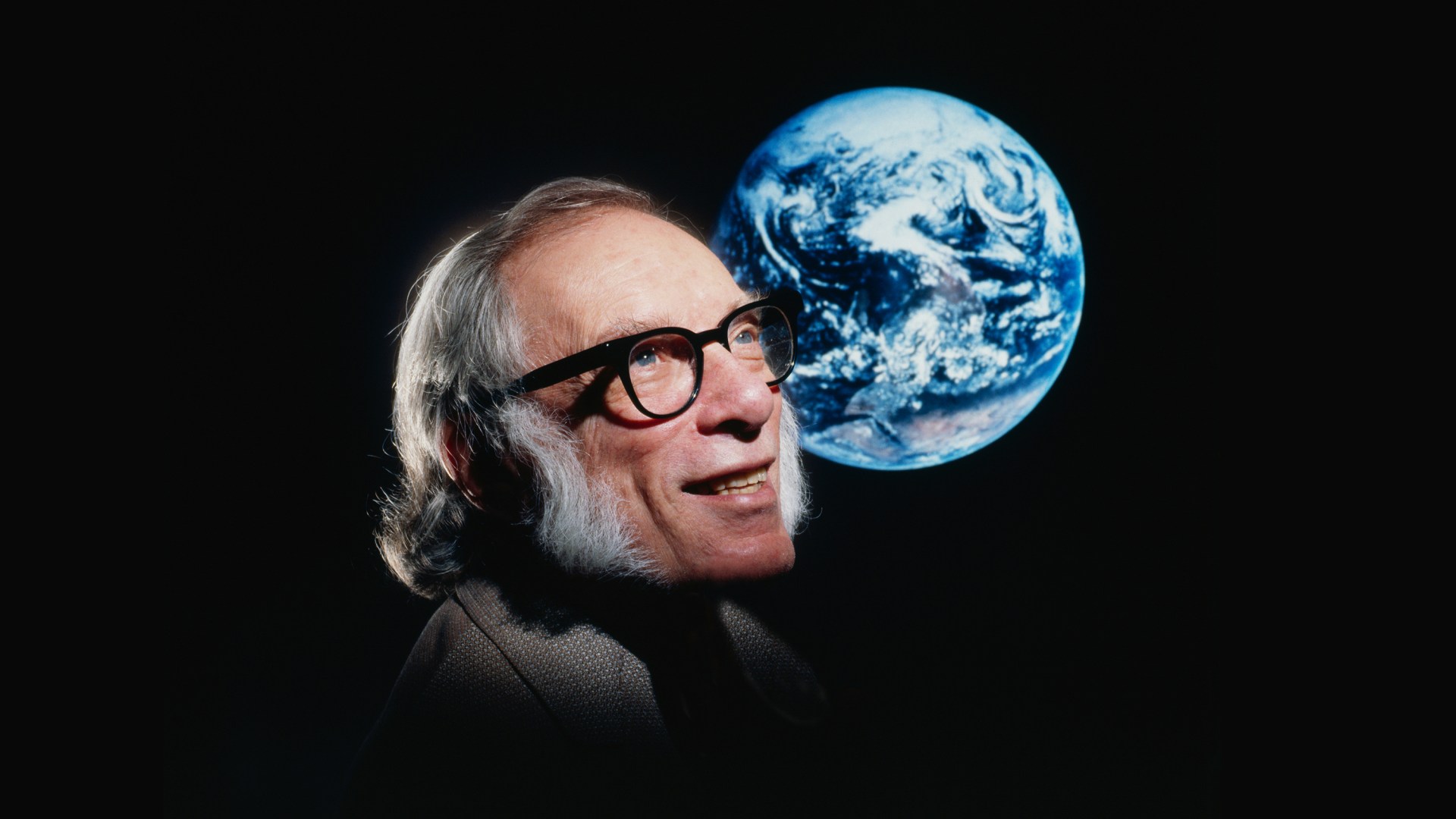 Le célèbre auteur de science-fiction Isaac Asimov avec une photo de la Terre vue de l’espace.