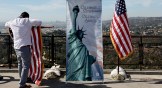 A man furls a flag after a US naturalization ceremony in Los Angeles for immigrants becoming citizens.