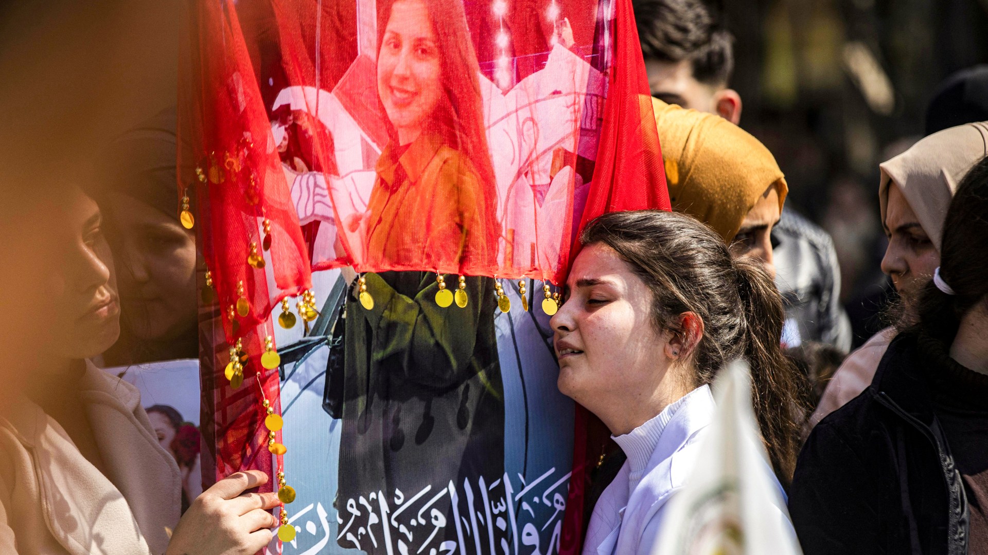 A woman reacts next to one of the pictures of victims of a recent wave of sectarian violence targeting Syria's Alawite minority.