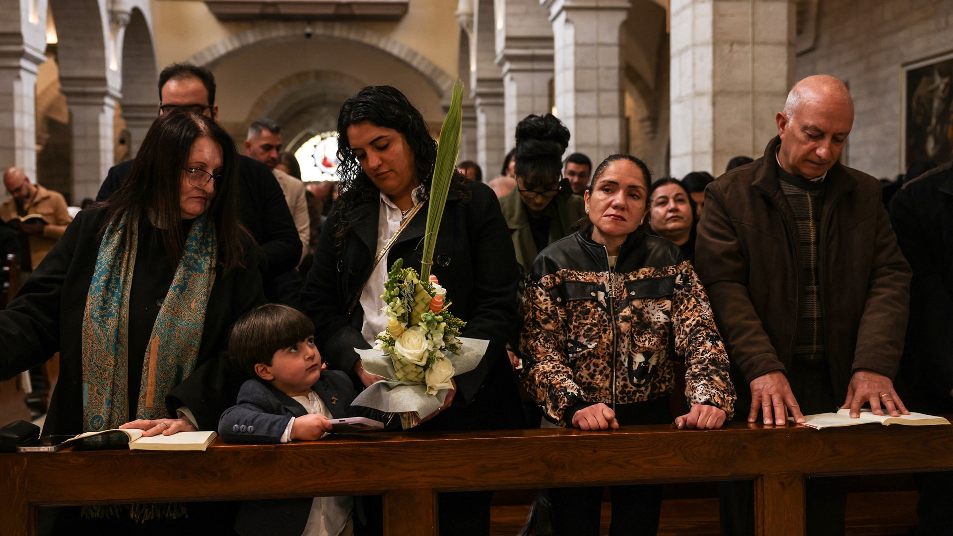 Des chrétiens assistent à la messe du dimanche des Rameaux à l'église catholique Sainte-Catherine, dans la ville de Bethléem, en Cisjordanie occupée, le 29 mars 2026.